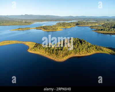 Ein malerischer Blick auf eine kleine Insel, umgeben von einem ruhigen Gewässer, mit zwei weiteren Inseln im Vordergrund Stockfoto