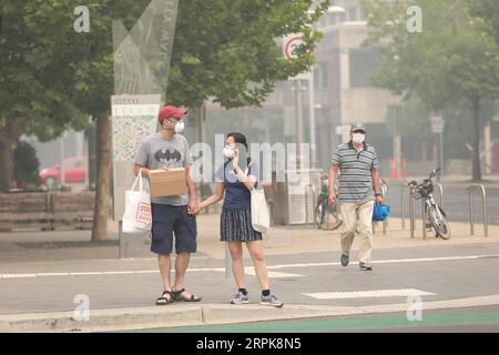 200102 -- CANBERRA, 2. Januar 2020 -- Anwohner tragen Gesichtsmasken als Schutz gegen schlechte Luftqualität in Canberra, Australien, 2. Januar 2020. Während einige Großstädte Australiens das neue Jahr 2020 mit Feuerwerk und Aufführungen feierten, ist die Hauptstadt des Landes in der Lage, von Buschbränden zu rauchen. Laut den neun Nachrichten ist Canberras Luftqualität heute die schlechteste aller großen Städte der Welt. Foto von /Xinhua AUSTRALIA-CANBERRA-BUSHFIRE-SMOKE-AIR QUALITY ChuxChen PUBLICATIONxNOTxINxCHN Stockfoto