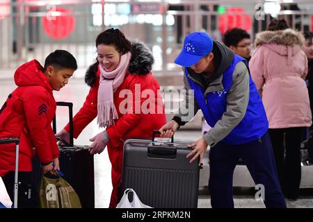 200113 -- LANZHOU, 13. Januar 2020 -- Ein Freiwilliger hilft Passagieren mit ihrem Gepäck am Lanzhou Bahnhof in Lanzhou, Hauptstadt der nordwestchinesischen Provinz Gansu, 13. Januar 2020. Während des Reisereims des Frühlingsfestes führen der Bahnhof Lanzhou und der Westbahnhof Lanzhou einen besonderen Freiwilligendienst namens Steward of the Journey ein. Für Passagiere, die Termine gemacht haben, in Eile in die Züge steigen oder nicht mit dem mobilen Fahrkartensystem vertraut sind, stehen Freiwillige zur Verfügung, die ihnen helfen, den Zug schneller zu besteigen und den Passagieren Komfort zu bieten Stockfoto