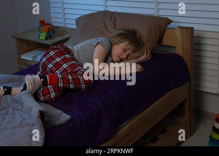 Ein kleiner Junge schnarcht nachts im Bett Stockfoto