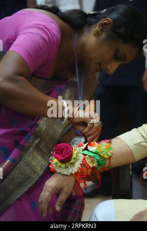 Eine Dame, die Rakhi und andere Rituale an Tripura cm Professor Dr. Manik Saha in seinem Amtssitz in Agartala bindet. Tripura, Indien. Stockfoto