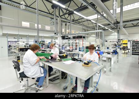 Frauen bei der Herstellung von Mikroelektronik in einer modernen Industriefabrik Stockfoto
