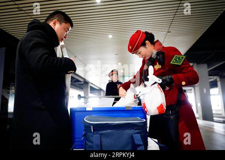 200121 -- SHIJIAZHUANG, 21. Januar 2020 -- Li Qi R überprüft das Essen zum Mitnehmen für Passagiere an einem Bahnhof in Shijiazhuang, nordchinesische Provinz Hebei, 21. Januar 2020. Das Frühlingsfest ist die größte Gelegenheit für Familientreffen in ganz China, aber für die Familie des 6-jährigen Zhang Anzhe sind Wiedervereinigungsmöglichkeiten selten. Zhangs Vater Zhang Peng ist Polizist und arbeitet im Polizeibüro des Bahnhofs Shijiazhuang, während seine Mutter Li Qi Chefdirigent in den Zügen zwischen Shijiazhuang und Wuhan ist. Beide Eltern waren während der Frühjahrsfest-Reisereisezeit so beschäftigt. Sie müssen Ma Stockfoto