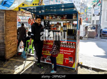 200126 -- GAZA, 26. Januar 2020 Xinhua -- Muhanad al-Aswad L spricht mit einem Kind an einem kleinen Stand, wo er Tee, Kaffee, Nescafe und Zigaretten verkauft, am 19. Januar 2020 in Gaza City. ZUM Beitrag: Palästinenser, die in Anti-Israel-Protesten verletzt wurden, kämpfen um die Wiederherstellung eines normalen Lebens Foto: Rizek Abdeljawad/Xinhua MIDEAST-GAZA-VERLETZTE-DEMONSTRANTEN PUBLICATIONxNOTxINxCHN Stockfoto