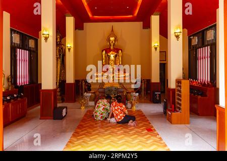 Bangkok, Thailand - 20. Februar 2023 - Ehepaar betend im Tempel Wat Saket vor dem goldenen Buddha. Stockfoto