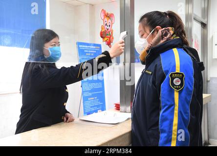 200127 -- PEKING, 27. Januar 2020 -- Ein Busfahrdienst misst die Temperatur eines Fahrers an einer Bushaltestelle in Peking, Hauptstadt von China, 27. Januar 2020. Die Beijing Public Transport Corporation hat Maßnahmen wie die Desinfektion von Bussen, die Messung der Temperaturen der Mitarbeiter und die Sicherstellung der Mitarbeiter, die mit Gesichtsmasken arbeiten, ergriffen, um die Ausbreitung des neuartigen Coronavirus zu verhindern. CHINA-PEKING-CORONAVIRUS-PUBLIC TRANSPORT-PREVENTION CN RENXCHAO PUBLICATIONXNOTXINXCHN Stockfoto