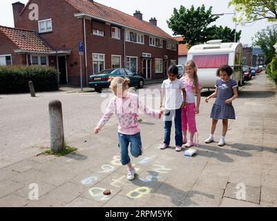 Niederlande, Arnhem, Mädchen spielen hopscotch. Stockfoto