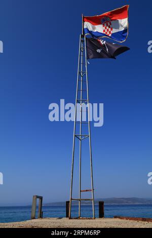 Kroatische Flagge und Piratenflagge auf einem hohen Mast Stockfoto