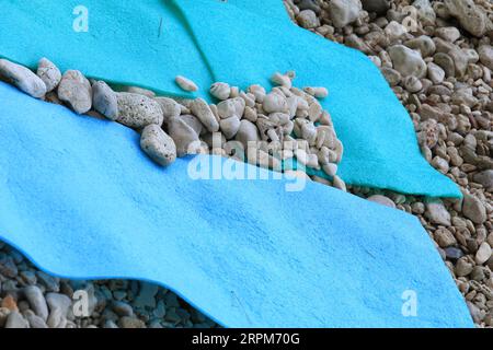 Steine auf der Schlafmatte zum Schutz vor Wind am Strand Stockfoto