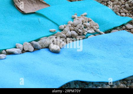 Steine auf der Schlafmatte zum Schutz vor Wind am Strand Stockfoto