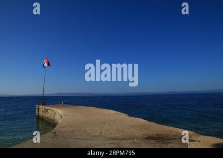 Betonpfeiler blaue Himmelsflagge von Kroatien Stockfoto