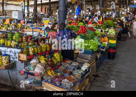 Ein überdachter Bauernmarkt in Telavi, der Hauptstadt des georgischen Weinbaugebiets Kakheti: Im Vordergrund werden Gefäße mit eingelegtem Gemüse und Kräutern sowie frische Tomaten, Paprika und Blattgemüse aufbewahrt. Kakheti, mit seiner fruchtbaren Alazani-Ebene am Fuße des Kaukasus, gilt als Georgiens Brotkorb und ist für seine reiche Marktkultur bekannt. Alazani Avenue, Gemeinde Telavi, Kakheti, 2200, Georgia Stockfoto