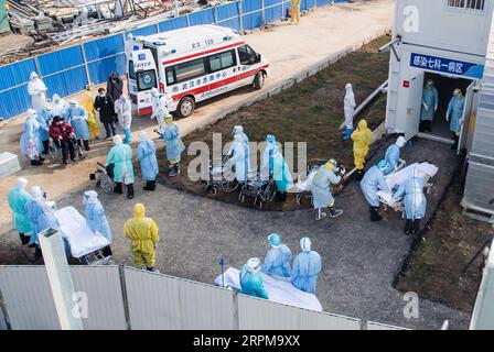 200205 -- PEKING, 5. Februar 2020 -- medizinische Mitarbeiter helfen der ersten Reihe von Patienten, die mit dem neuartigen Coronavirus infiziert sind, in ihre Isolationsstationen im Huoshenshan Fire God Mountain Hospital in Wuhan, zentralchinesische Provinz Hubei, 4. Februar 2020. Ein neu errichtetes Krankenhaus in Wuhan, dem Epizentrum des neuartigen Coronavirus-Ausbruchs in China, begann am Dienstag mit der Aufnahme von Patienten, die mit dem Virus infiziert waren. Die erste Patientencharge wurde in das Huoshenshan Krankenhaus gebracht, das am Sonntag nach einem 10-tägigen Bau geliefert wurde. XINHUA FOTOS DES TAGES XiaoxYijiu PUBLICATIONxNOTxINxCHN Stockfoto