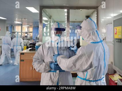 200205 -- WUHAN, 5. Februar 2020 Xinhua -- das Foto, das am 5. Februar 2020 mit einem Mobiltelefon aufgenommen wurde, zeigt einen Arzt, der den Namen auf dem Schutzanzug für Peng Zhiyong L, Front, den Direktor der Intensivstation, in einer Isolationsstation im Zhongnan Krankenhaus der Wuhan Universität in Wuhan, Provinz Hubei, schreibt. Gesundheitsarbeiter schreiben Namen auf ihre Schutzanzüge für einander, um in den Isolationsstationen Anerkennung zu finden. Foto von Zhong Nanxuan/Xinhua InWardCHINA-HUBEI-WUHAN-ISOLATION STATION-MEDICAL WORKER CN PUBLICATIONxNOTxINxCHN Stockfoto