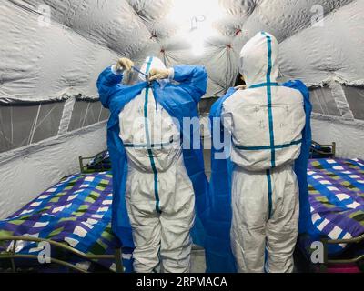 200205 -- WUHAN, 5. Februar 2020 -- die Gesundheitsarbeiter Fan Xiao und Jiang Li vom zweiten Xiangya Krankenhaus der Central South University tragen Schutzanzüge im Hongshan Gymnasium, einem Ort, der in ein provisorisches Krankenhaus umgewandelt wurde, um Patienten zu empfangen, die mit dem neuartigen Coronavirus 2019-nCoV infiziert sind, in Wuhan, Provinz Hubei in Zentralchina, 5. Februar 2020. ZU XINHUA-SCHLAGZEILEN VON FEB. 5, 2020. CHINA-HUBEI-WUHAN-CORONAVIRUS-MAKESHIFT KRANKENHÄUSER CN SHUAIXCAI PUBLICATIONXNOTXINXCHN Stockfoto