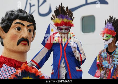 Philippinische fiesta-Motto Willkommensfeier für Kreuzfahrtschiff am Manila Pier : Musiker mit Bambusinstrumenten, philippinische Tänzer, Higantes, Flaggen Stockfoto