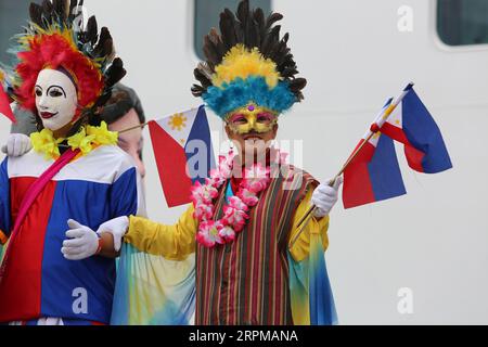 Philippinische fiesta-Motto Willkommensfeier für Kreuzfahrtschiff am Manila Pier : Musiker mit Bambusinstrumenten, philippinische Tänzer, Higantes, Flaggen Stockfoto