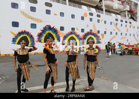 Philippinische fiesta-Motto Willkommensfeier für Kreuzfahrtschiff am Manila Pier : Musiker mit Bambusinstrumenten, philippinische Tänzer, Higantes, Flaggen Stockfoto