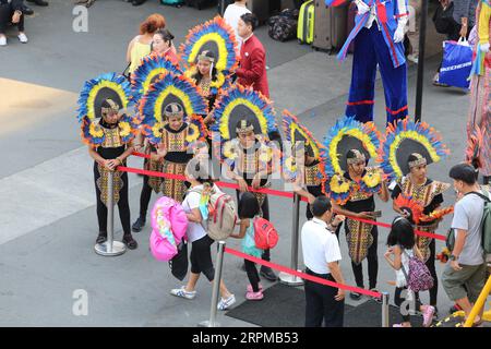 Philippinische fiesta-Motto Willkommensfeier für Kreuzfahrtschiff am Manila Pier : Musiker mit Bambusinstrumenten, philippinische Tänzer, Higantes, Flaggen Stockfoto