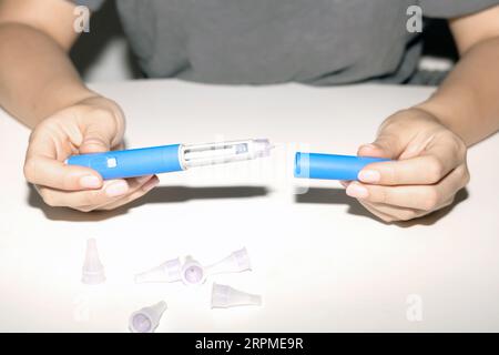 Weibliche Hände, die einen Insulinpen halten. Ozempic Insulin-Injektions-Pen oder Insulin-Patronen-Pen für Diabetiker. Medizinische Geräte für Diabeteskranke. Stockfoto