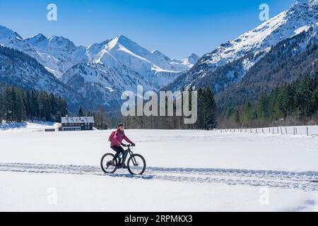 Eine nette Seniorin, die an einem sonnigen Wintertag in den Allgauer alpen bei Oberstdorf, Bayern, mit dem ElektroMountainbike unterwegs ist Stockfoto