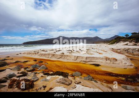 Wineglass Bay Beach und seine orangen Flechtensteine an einem rauen Tag auf der Freycinet Peninsula in Tasmanien, Australien Stockfoto