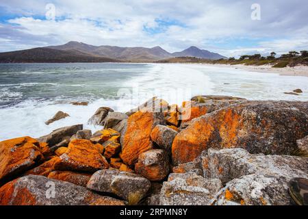 Wineglass Bay Beach und seine orangen Flechtensteine an einem rauen Tag auf der Freycinet Peninsula in Tasmanien, Australien Stockfoto