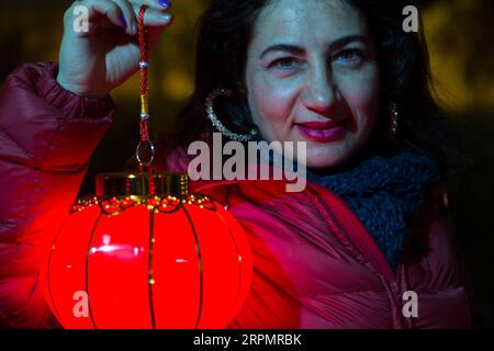 200216 -- ATHEN, 16. Februar 2020 -- Eine Frau hält eine rote Laterne am Fuße des Akropolis-Hügels in Athen, Griechenland, 14. Februar 2020. Der Fußgängerweg am Fuße des Akropolis-Hügels im Herzen Athens war am Freitagabend für eine Stunde rot beleuchtet, während Griechen und Chinesen, die in Griechenland lebten, eine symbolische Versammlung hielten und mit chinesischen roten Laternen durch das Viertel liefen. Unter der Schirmherrschaft der Stadt Athen, der Kammer für griechisch-chinesische wirtschaftliche Zusammenarbeit, zusammen mit Wirtschaftsverbänden der chinesischen Gemeinschaft in Athen und anderen Gruppen, die die Bürger Athens vertreten, o Stockfoto