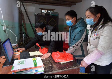 200218 -- NANCHANG, 18. Februar 2020 -- Luo Changshi L, der Schulleiter der Xinzhu Grundschule, lädt Online-Kurse für Schüler Guo taifeng C und Guo Xiaofang im Dorf Xinzhu im Wanzai County, ostchinesische Provinz Jiangxi, 17. Februar 2020 herunter. China hat das Frühjahrssemester aufgrund des Coronavirus-Ausbruchs verschoben, der bis Sonntag landesweit über 70.000 Menschen infiziert hat. Millionen von Schülern, die zu Hause blieben, wandten sich mit Beginn der Schulzeit dem Online-Lernen zu. Die Provinz Jiangxi hat seit dem 10. Februar Online-Kurse für Studenten im Zusammenhang mit dem neuartigen Coronavirus-Ausbruch begonnen. Stockfoto