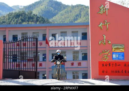 200218 -- NANCHANG, 18. Februar 2020 -- Luo Changshi, der Schulleiter der Xinzhu Elementary School, verlässt die Schule, um Kurse zu liefern, die aus Online-Kursen kopiert wurden, und neue Lehrbücher für Schüler im Dorf Xinzhu im Wanzai County, ostchinesische Provinz Jiangxi, 18. Februar 2020. China hat das Frühjahrssemester aufgrund des Coronavirus-Ausbruchs verschoben. Millionen von Schülern, die zu Hause blieben, wandten sich mit Beginn der Schulzeit dem Online-Lernen zu. Die Provinz Jiangxi hat seit dem 10. Februar Online-Kurse für Studenten im Zusammenhang mit dem neuartigen Coronavirus-Ausbruch begonnen. Luo Changshi, der Direktor von Xinzhu Stockfoto