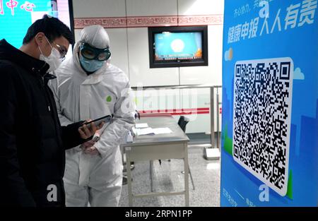 200220 -- ZHENGZHOU, 20. Februar 2020 -- Ein Mitarbeiter überprüft die Informationen eines Bewohners, nachdem dieser einen QR-Code an einem Eingang zu einer U-Bahn-Station in Zhengzhou, der zentralchinesischen Provinz Henan, am 19. Februar 2020 gescannt hat. Die Stadt Zhengzhou in der Provinz Henan hat am Mittwoch ein QR-Code-System eingeführt, das mit dem System zur Registrierung von Gesundheitszuständen für Wohngemeinschaften verbunden ist. Bewohner der Stadt können jetzt QR-Codes verwenden, um den Transport zu nehmen und einzukaufen. Alle Informationen werden gesammelt und an eine integrierte Datenplattform zur Prävention und Bekämpfung von Epidemien in übermittelt Stockfoto