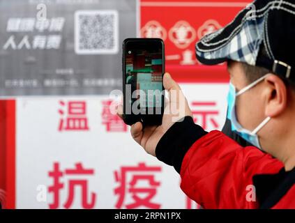 200220 -- ZHENGZHOU, 20. Februar 2020 -- Ein Bewohner scannt einen QR-Code an einem Eingang zu einem Supermarkt in Zhengzhou, zentralchinesische Provinz Henan, 19. Februar 2020. Die Stadt Zhengzhou in der Provinz Henan hat am Mittwoch ein QR-Code-System eingeführt, das mit dem System zur Registrierung von Gesundheitszuständen für Wohngemeinschaften verbunden ist. Bewohner der Stadt können jetzt QR-Codes verwenden, um den Transport zu nehmen und einzukaufen. Alle Informationen werden gesammelt und an eine integrierte Datenplattform zur Prävention und Bekämpfung von Epidemien in Echtzeit übermittelt, um den Ausbruch des neuartigen Coronavi zu bekämpfen Stockfoto