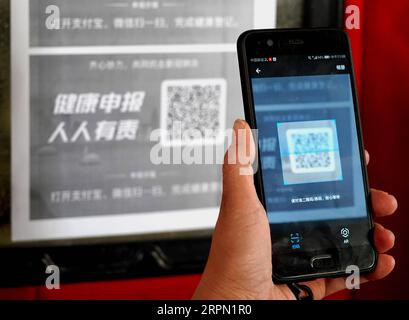 200220 -- ZHENGZHOU, 20. Februar 2020 -- Ein Bewohner scannt einen QR-Code an einem Eingang zu einem Supermarkt in Zhengzhou, zentralchinesische Provinz Henan, 19. Februar 2020. Die Stadt Zhengzhou in der Provinz Henan hat am Mittwoch ein QR-Code-System eingeführt, das mit dem System zur Registrierung von Gesundheitszuständen für Wohngemeinschaften verbunden ist. Bewohner der Stadt können jetzt QR-Codes verwenden, um den Transport zu nehmen und einzukaufen. Alle Informationen werden gesammelt und an eine integrierte Datenplattform zur Prävention und Bekämpfung von Epidemien in Echtzeit übermittelt, um den Ausbruch des neuartigen Coronavi zu bekämpfen Stockfoto