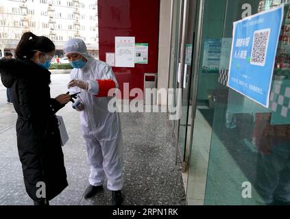 200220 -- ZHENGZHOU, 20. Februar 2020 -- Ein Mitarbeiter hilft einem Bewohner, Informationen einzugeben, nachdem dieser einen QR-Code an einem Eingang zu einem Einkaufszentrum in Zhengzhou, der zentralchinesischen Provinz Henan, am 19. Februar 2020 gescannt hat. Die Stadt Zhengzhou in der Provinz Henan hat am Mittwoch ein QR-Code-System eingeführt, das mit dem System zur Registrierung von Gesundheitszuständen für Wohngemeinschaften verbunden ist. Bewohner der Stadt können jetzt QR-Codes verwenden, um den Transport zu nehmen und einzukaufen. Alle Informationen werden gesammelt und an eine integrierte Datenplattform zur Prävention und Bekämpfung von Epidemien in übermittelt Stockfoto