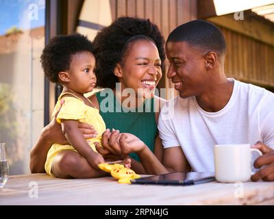 Familienaufnahmen, Als Eltern Mit Der Jungen Tochter Zu Hause Spielen, Während Sie Ein Digitales Tablet Verwenden Stockfoto