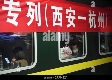 200224 -- XI AN, 24. Februar 2020 -- Wanderarbeiter aus Luonan County steigen in einen Sonderzug nach Hangzhou am Xi an Bahnhof in Xi an, Provinz Shaanxi im Nordwesten Chinas, 24. Februar 2020. Insgesamt 951 Wanderarbeiter aus dem Luonan County nahmen am Montag den Sonderzug, um ihre Arbeit im Yangtze-Delta wieder aufzunehmen. CHINA-XI AN-SPECIAL TRAIN-MIGRANTIN CN LIXYIBO PUBLICATIONXNOTXINXCHN Stockfoto