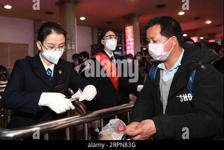 200224 -- XI AN, 24. Februar 2020 -- Ein Wanderarbeiter aus Luonan County prüft sein Ticket, um an Bord eines Sonderzuges nach Hangzhou am Xi an Bahnhof in Xi an, Provinz Shaanxi im Nordwesten Chinas, 24. Februar 2020 zu gelangen. Insgesamt 951 Wanderarbeiter aus dem Luonan County nahmen am Montag den Sonderzug, um ihre Arbeit im Yangtze-Delta wieder aufzunehmen. CHINA-XI AN-SPECIAL TRAIN-MIGRANTIN CN LIXYIBO PUBLICATIONXNOTXINXCHN Stockfoto