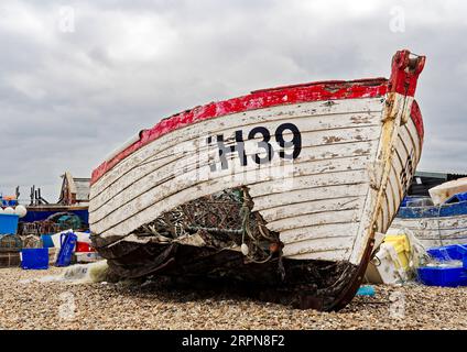 Das verlassene und beschädigte Fishihg-Boot verrottet am Kiesstrand von Aldeburgh, Suffolk, bietet eine malerische, wenn auch traurige Kulisse für diesen Teil der Stadt. Stockfoto