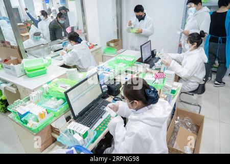 200228 -- WUHAN, 28. Februar 2020 -- Mitarbeiter der Apotheke geben Medikamente in der Apotheke Hankou in der Huangshi Road in Wuhan, Provinz Hubei in Zentralchina, 27. Februar 2020. Diese Filiale der Hankou Apotheke ist eine ausgewiesene Apotheke für Medikamente gegen chronische schwere Krankheiten. Die Mitarbeiter hier müssen oft vom frühen Morgen bis spät in die Nacht arbeiten, um die Nachfrage zu befriedigen, und geben durchschnittlich 1.000 Bestellungen aus, die 30.000 Packungen Arzneimittel pro Mitarbeiter pro Tag umfassen. CHINA-HUBEI-WUHAN-APOTHEKE CN CaixYang PUBLICATIONxNOTxINxCHN Stockfoto