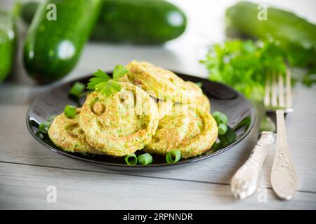 Gebratene Kürbiskuchen auf einem Teller, auf einem Holztisch. Stockfoto