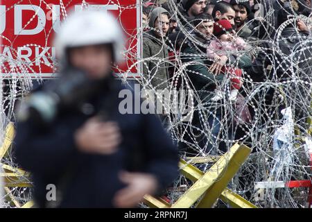 200303 -- PEKING, 4. März 2020 -- Migranten und Flüchtlinge werden hinter einem Drahtzaun an der Grenze zwischen Griechenland und der Türkei nahe dem geschlossenen Grenzübergang Kastanies im Nordosten Griechenlands gesehen, wo sich am 2. März 2020 Tausende in der Nähe des Flusses Evros versammelten, um nach Griechenland zu gelangen. Griechenland hat am Sonntag beschlossen, die Abschreckung an seinen Grenzen auf das Maximum zu erhöhen, da das Land in jüngster Zeit mit einem zunehmenden Flüchtlings- und Migrantenzustrom konfrontiert ist. Foto von /Xinhua XINHUA FOTOS DES TAGES DimitrisxTosidis PUBLICATIONxNOTxINxCHN Stockfoto