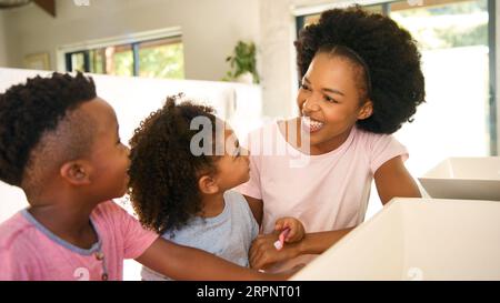 Mutter Hilft Kindern Beim Zähneputzen Im Badezimmer Zu Hause Vor Dem Schlafengehen Stockfoto