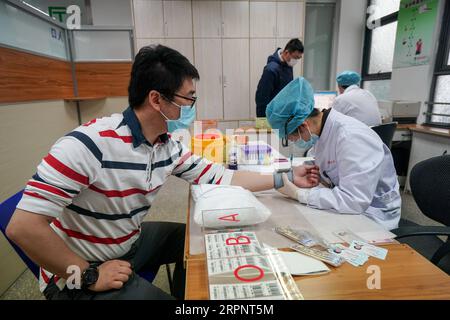 200304 -- NANJING, 4. März 2020 -- Ein Mann unterzieht sich einer körperlichen Untersuchung, bevor er sein Blut im Nanjing Red Cross Blood Center in Nanjing, der ostchinesischen Provinz Jiangsu, spendet, 4. März 2020. Viele Bewohner in Nanjing meldeten sich freiwillig, ihr Blut vor dem Lei Feng Day zu spenden, der jedes Jahr am 5. März stattfindet, um anderen zu helfen, um an den Soldaten zu erinnern, der für seine Großzügigkeit und seine altruistischen Taten bekannt ist. CHINA-JIANGSU-NANJING-FREIWILLIGENBLUTSPENDE CN JIXCHUNPENG PUBLICATIONXNOTXINXCHN Stockfoto