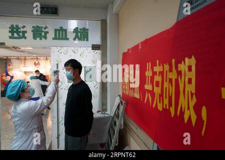 200304 -- NANJING, 4. März 2020 -- Ein Mann nimmt eine Temperaturkontrolle vor, bevor er sein Blut im Nanjing Red Cross Blood Center in Nanjing, der ostchinesischen Provinz Jiangsu, spendet, 4. März 2020. Viele Bewohner in Nanjing meldeten sich freiwillig, ihr Blut vor dem Lei Feng Day zu spenden, der jedes Jahr am 5. März stattfindet, um anderen zu helfen, um an den Soldaten zu erinnern, der für seine Großzügigkeit und seine altruistischen Taten bekannt ist. CHINA-JIANGSU-NANJING-FREIWILLIGENBLUTSPENDE CN JIXCHUNPENG PUBLICATIONXNOTXINXCHN Stockfoto