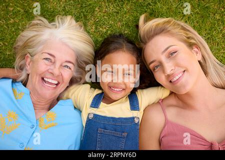 Overhead-Aufnahme Einer Weiblichen Mehrgenerationenfamilie, Die Auf Gras Liegt Stockfoto