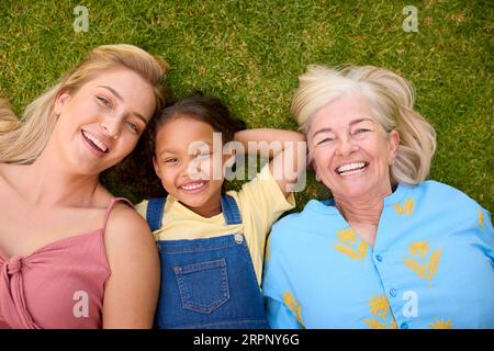 Overhead-Aufnahme Einer Weiblichen Mehrgenerationenfamilie, Die Auf Gras Liegt Stockfoto