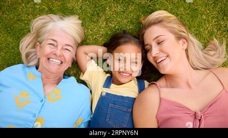 Overhead-Aufnahme Einer Weiblichen Mehrgenerationenfamilie, Die Auf Gras Liegt Stockfoto