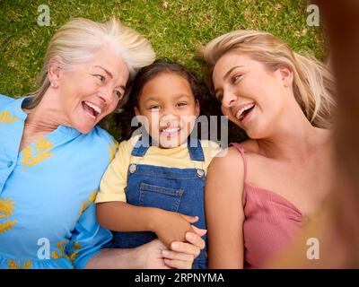 POV Overhead Shot von Multi-Generation Female Family Living on Grass Taking Selfie on Mobile Phone Stockfoto