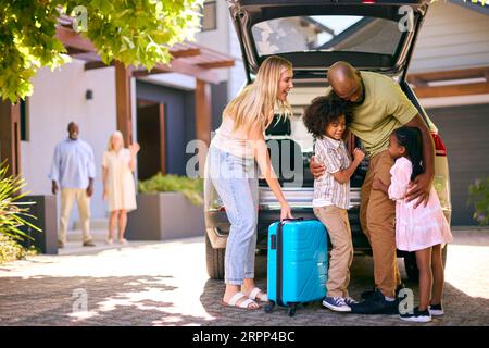 Familie Lädt Auto Und Sagt Abschied Nach Dem Besuch Bei Großeltern Stockfoto