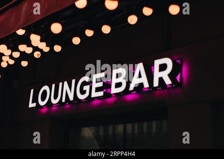 Neonschild auf schwarzem Hintergrund, Aufschrift Lounge Bar mit rosa Licht Stockfoto